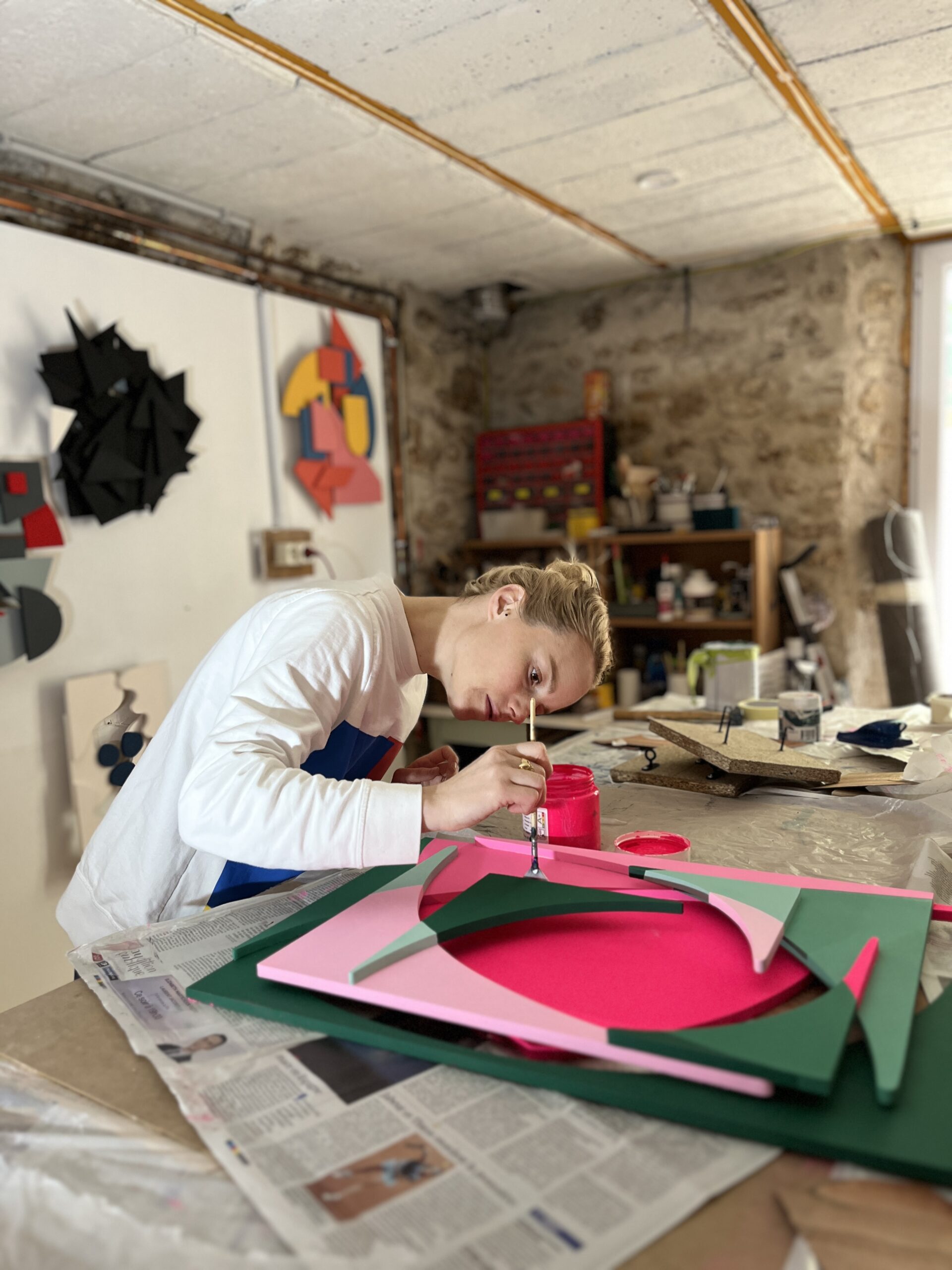 Amicie de Bouteiller peignant une sculpture dans son atelier