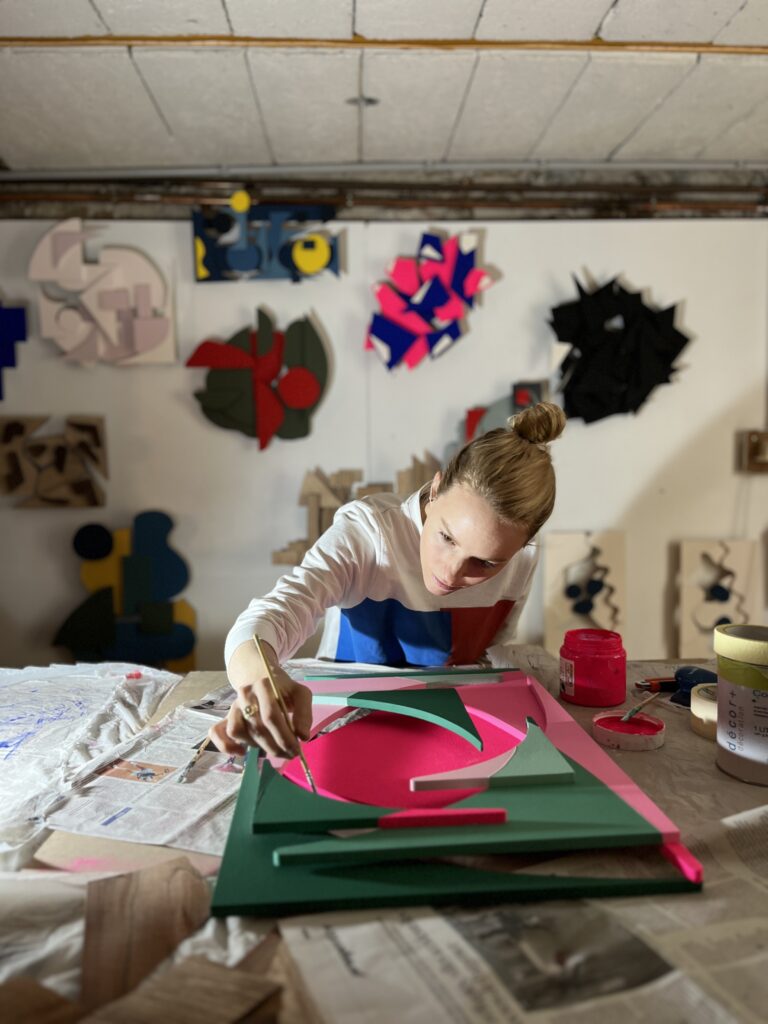 Amicie de Bouteiller peignant une sculpture dans son atelier